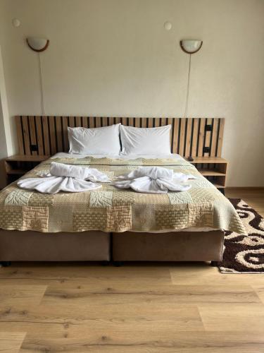 a bed with white pillows and a blanket on it at Guest House Raffe in Dobrinishte