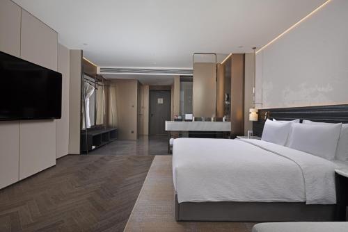 a hotel room with a bed and a flat screen tv at Wanda Yi, Beijing Qianmen - Close to Tiananmen Square in Beijing