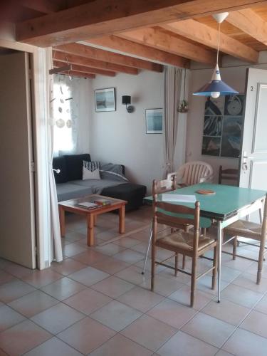 un salon avec une table et un canapé dans l'établissement Appt vue imprenable sur la mer, à Gruissan