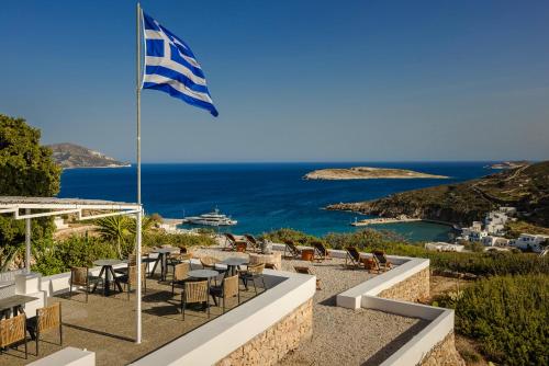 a flag flying over a patio with a view of the ocean at The Windmill Kimolos in Kimolos