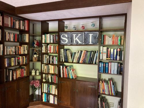 a library with book shelves filled with books at 3 Bed Apartment with Private Terrace, Communal Pool, Mont Blanc Views in Saint-Gervais-les-Bains