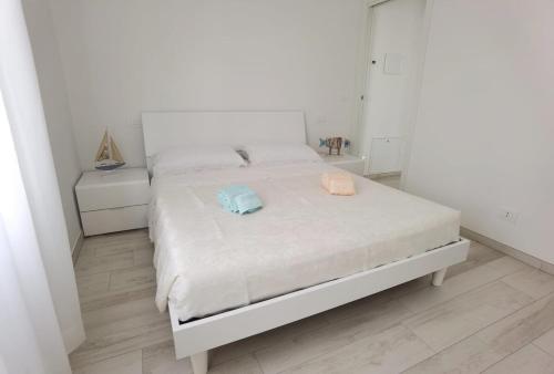 a white bedroom with a bed with two towels on it at A casa di Azzurra in Roseto degli Abruzzi