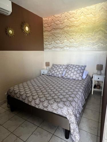 a bedroom with a bed and two lights on the wall at Domaine Les feuilles de Chêne in Carpentras