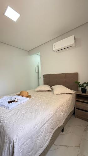 a bedroom with a large bed with white sheets at Apto Flor de Romã - 2 Quartos, Apto todo climatizado, à 150m do Parque Termal! in Piratuba