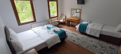 a hotel room with two beds and a mirror at Uzungol Soylu Hotel in Uzungöl