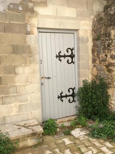 La Maison d'Estelle في Lavérune: باب أبيض على مبنى من الطوب بجدار حجري