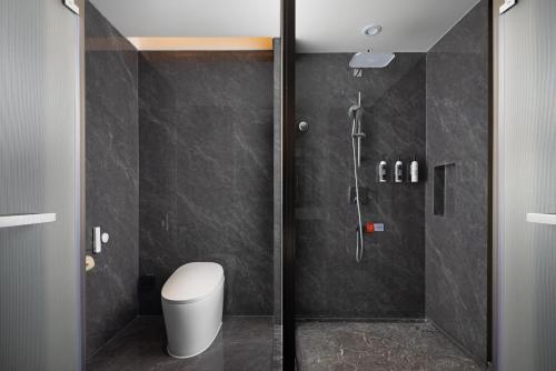 a bathroom with a glass shower with a toilet at Wanda Yi, Beijing Qianmen - Close to Tiananmen Square in Beijing