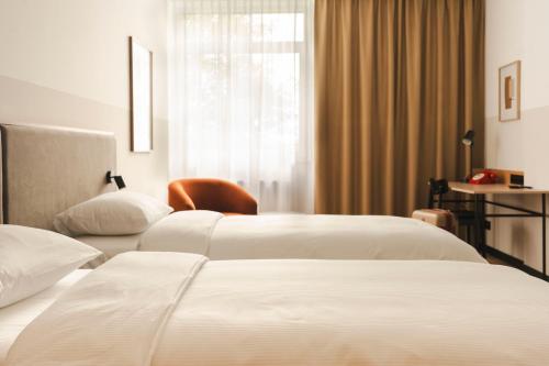 two beds in a hotel room with a window at Hotel Node 