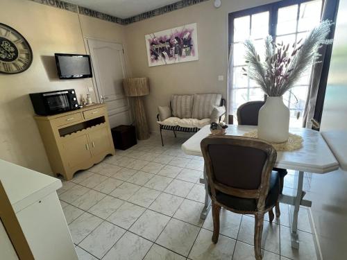 a living room with a table with a vase on it at Domaine Les feuilles de Chêne in Carpentras