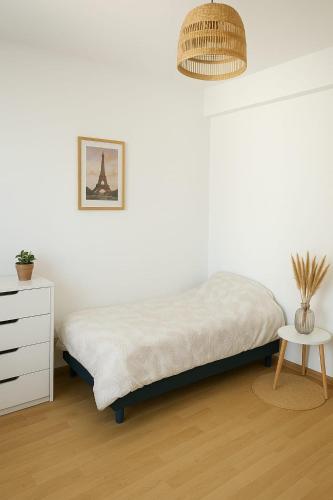 une chambre blanche avec un lit et une table dans l'établissement Appartement spacieux de 92m2, à Brest