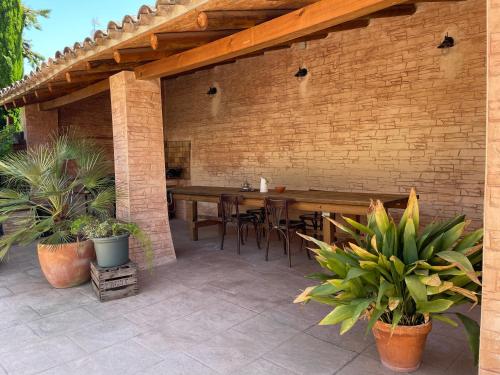 a patio with a table and chairs and a brick wall at Cal General in San Vicente de Castellet