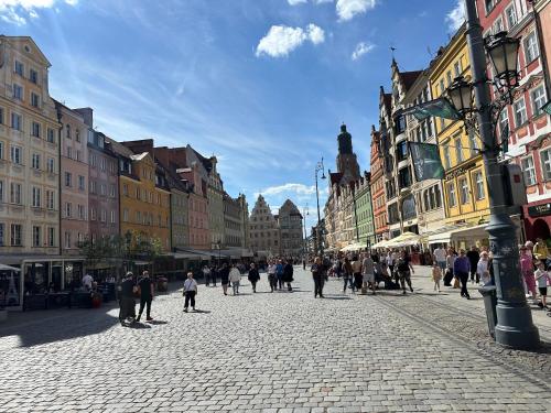 Boulevard Drobnera IV - Apartament nad Odrą - Rynek في فروتسواف: مجموعة من الناس يسيرون في شارع
