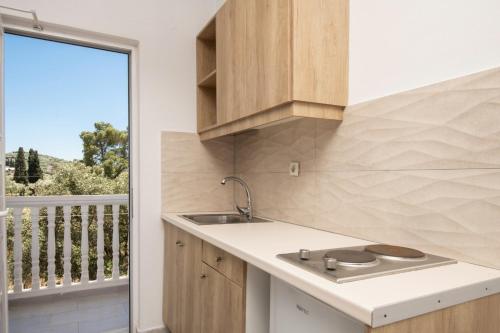a kitchen with a counter and a sink and a balcony at Akis Studios Alykes in Alykes