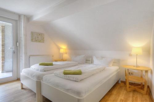 two beds in a white room with two lamps at Göckes Haus Und Garten Wiesenblick in Wettringen