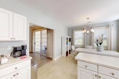 Una cocina con gabinetes blancos y encimera. en Havens #915, en Myrtle Beach