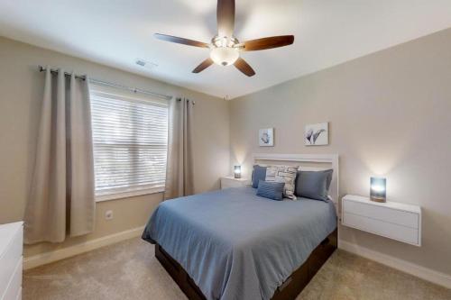 Un dormitorio con una cama y un ventilador de techo. en Havens #915, en Myrtle Beach