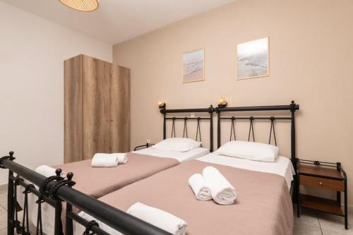 two beds in a bedroom with white towels at Akis Studios Alykes in Alykes