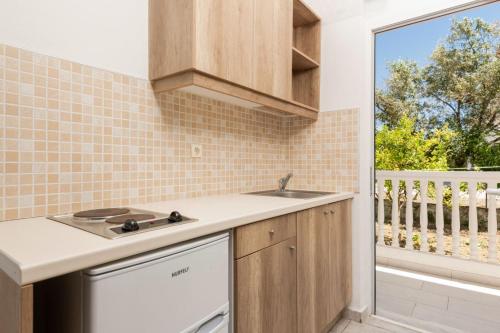 a kitchen with a sink and a window at Akis Studios Alykes in Alykes
