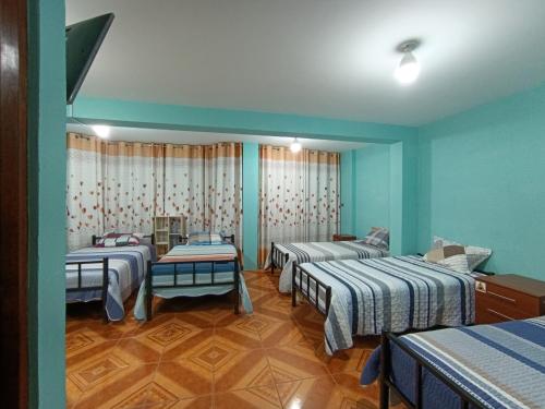 a room with four beds in it with blue walls at La Casa del NONO in Cajamarca