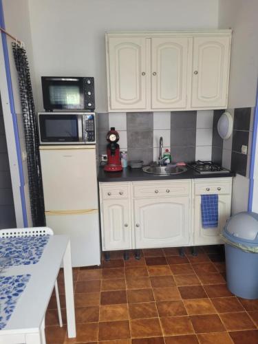 une petite cuisine avec des armoires blanches et un évier dans l'établissement Studio, à Dunkerque