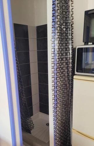 un miroir de salle de bain avec douche et un micro-ondes dans l'établissement Studio, à Dunkerque