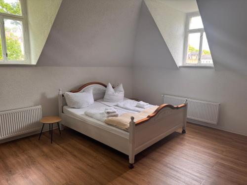 a white bed in a room with two windows at Villa Dietel Greiz in Greiz