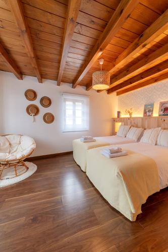 two beds in a large room with wooden ceilings at La Olivia 53 Boutique con zona Chill Out A 5 min de Cangas de Onís in Cangas de Onís