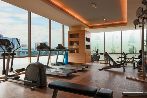 a gym with treadmills and ellipticals in a room with windows at Holiday Inn Chennai OMR IT Expressway by IHG in Chennai