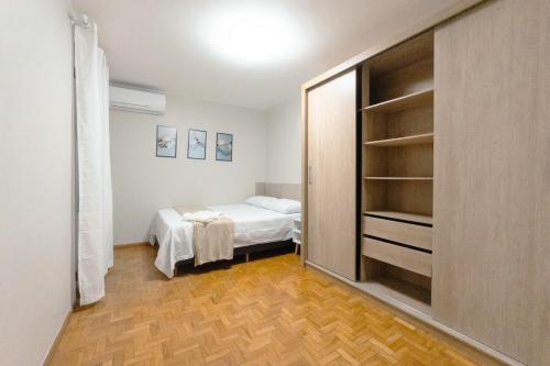 a small bedroom with a bed and a closet at Conforto no Centro de Maringá MC11 in Maringá