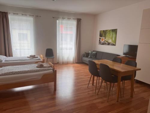 a room with two beds and a table and a couch at Apartment im Herzen von Neusiedl am See in Neusiedl am See