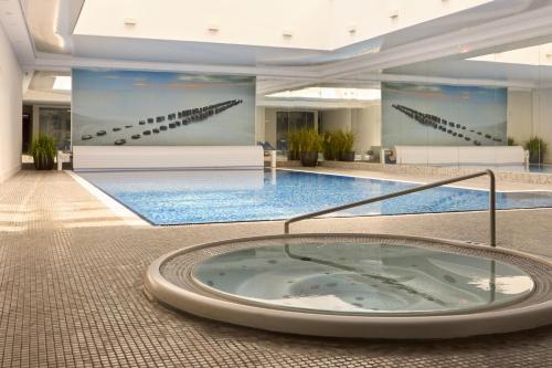 a large swimming pool with a hot tub in a building at Waterlane Riverside SPA, Pool & Gym by Downtown Apartments in Gdańsk