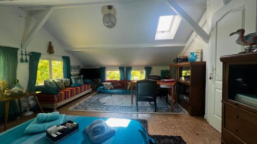 sala de estar con cama azul y sofá en LeLoft au dessus des Pins, en Lacanau