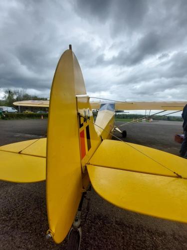 a yellow plane is parked on a runway at Au Coq et fa gnes in Jalhay
