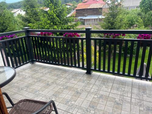 a black fence with a table and chairs on a patio at Guest House Raffe in Dobrinishte