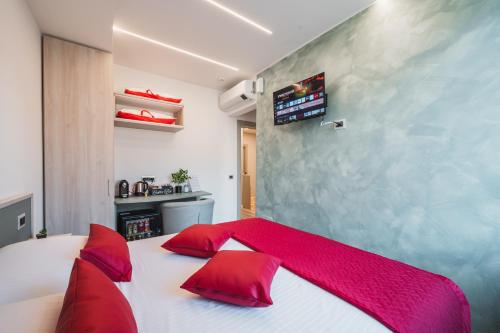 a bedroom with a white bed with red pillows at Affittacamere I Tesori di Modena - Malmusi in Modena