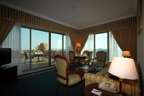 a hotel room with a couch and chairs and a large window at Al Ahsa InterContinental by IHG in Al Ahsa