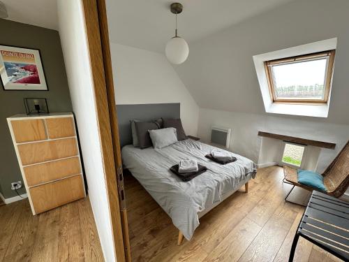 a bedroom with a bed and a window at Le 16 du Bout du Monde in Cléden-Cap-Sizun