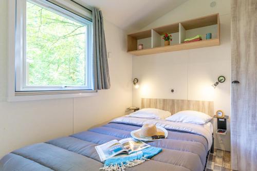 deux lits dans une chambre avec une fenêtre dans l'établissement Camping Le Hameau du Petit Lay, à Mouchamps