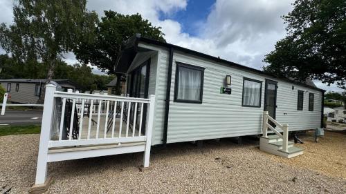 a small white tiny house with a white railing at Beamish Holiday Park in Stanley