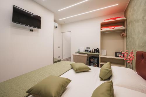 a bedroom with a white bed with green pillows at Affittacamere I Tesori di Modena - Malmusi in Modena