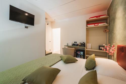 a bedroom with a bed with a television on the wall at Affittacamere I Tesori di Modena - Malmusi in Modena
