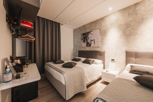a hotel room with two beds and a television at Affittacamere I Tesori di Modena - Malmusi in Modena