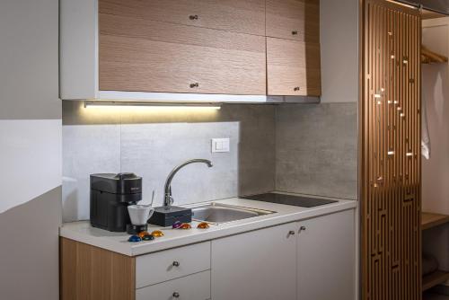 a kitchen with a sink and a coffee maker at Mary Hotel & Mary Royal Suites in Platanes