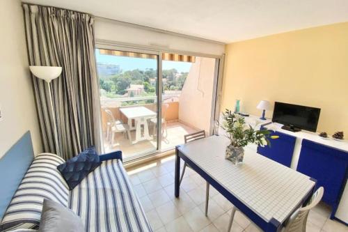 un salon avec un canapé et une table dans l'établissement Bright studio with balcony near the harbor, à Saint-Raphaël