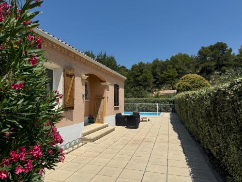 une cour d'une maison avec une haie dans l'établissement Maison Minervois, à Agel