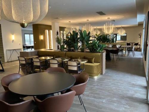 a lobby with tables and chairs in a building at Montana Dijon in Dijon