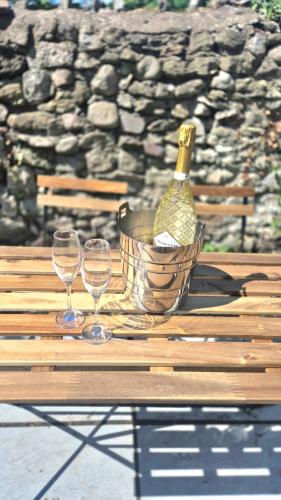 a basket with a bottle of wine and two glasses on a table at Fig Tree Cottage in North Cornelly