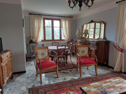 a dining room with a table and chairs and a mirror at La Gineste in Serres