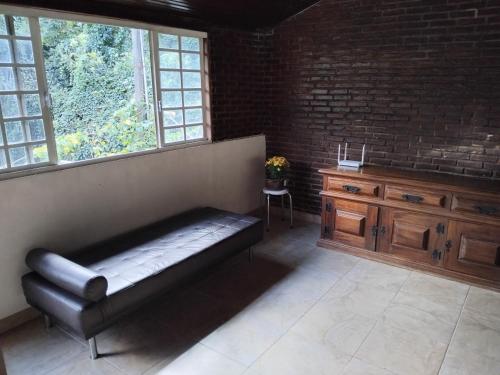 a living room with a bench and a brick wall at Casa Térrea e Rústica - Serra da Cantareira in Mairiporã