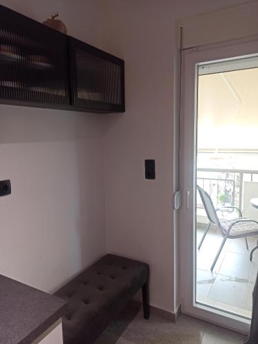 a living room with a couch and a sliding glass door at Sodi Cozy apartment in Kardítsa